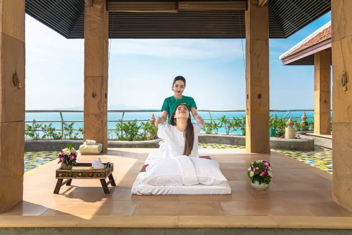 woman stretching her back at rooftop of cliff spa